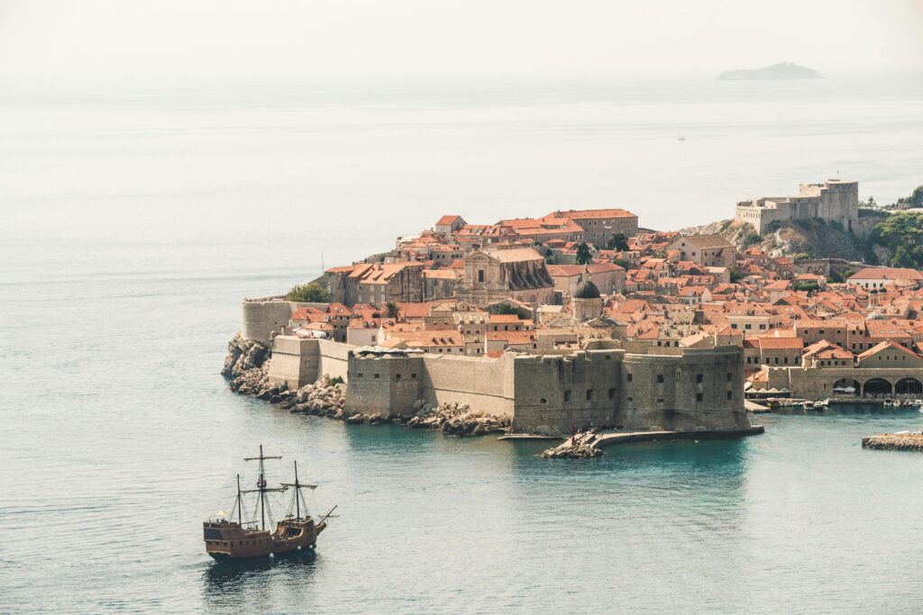Adriyatik Denizi kıyısındaki Dubrovnik’in eski şehri ve tarihi surlarını gösteren büyüleyici bir hava fotoğrafı.