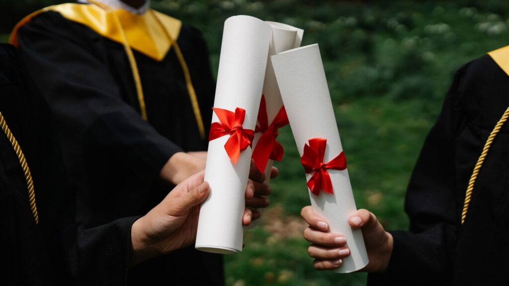 Kurdeleli diplomalarını tutan mezunlar